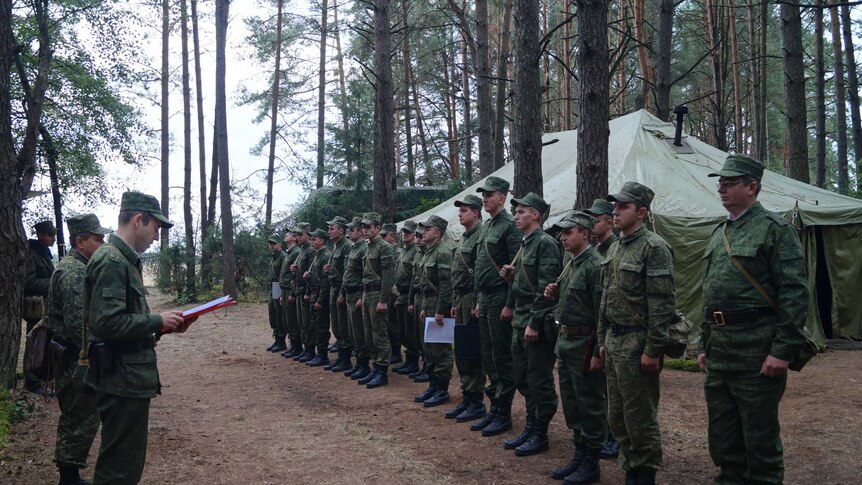 Soldiers from Belarus line up to hear an order, which begins the drills. They are at a forested training ground in Belarus.