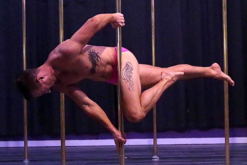 Man clings to pole horizontally