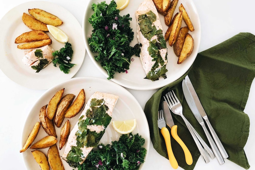 Two adult servings of salmon, potato wedges and kale salad with one kid sized serving from our easy recipe.