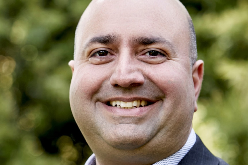 Zareh Ghazarian smiles in a suit.