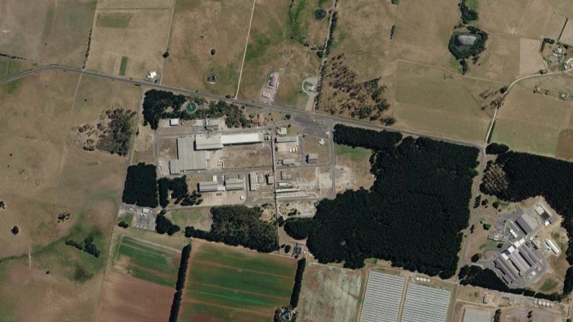 A satellite image of an industrial site, surrounded by agricultural land.
