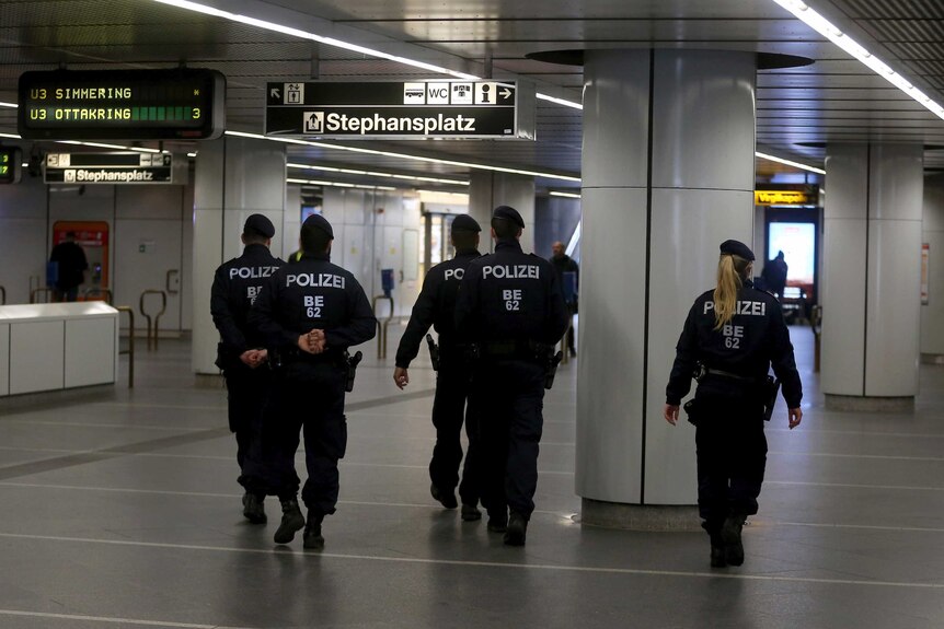 Police walk through Austria public transport areas.