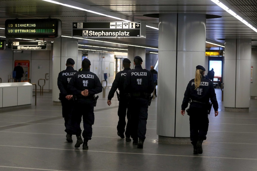 Police walk through Austria public transport areas.