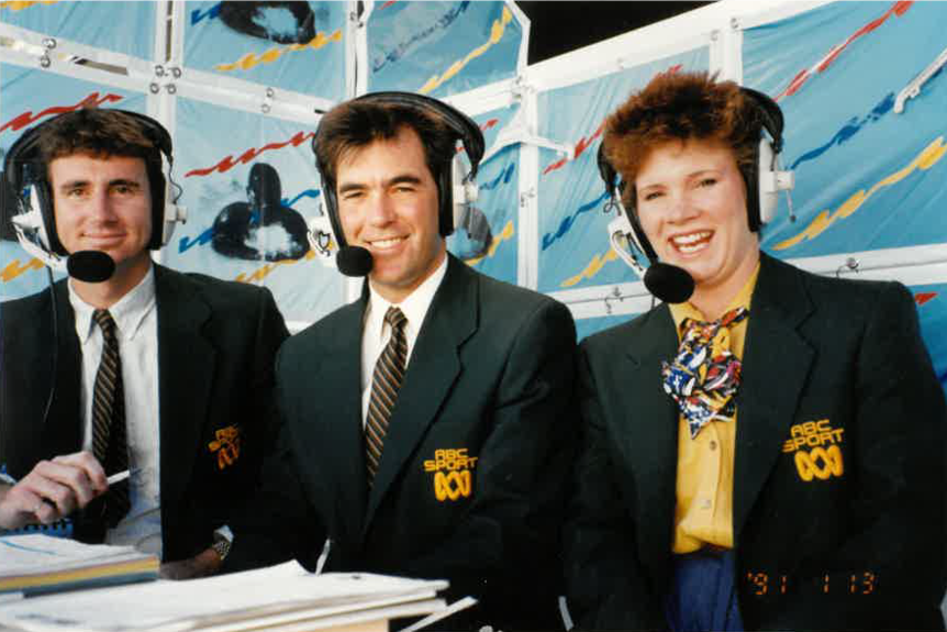 Three commentators wearing green ABC Sport jackets and head sets.