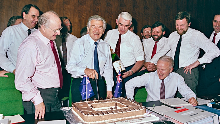 Bob Hawke, surrounded by other ministers and staff, cuts a cake at the last cabinet meeting in the Old Cabinet Room in 1988.