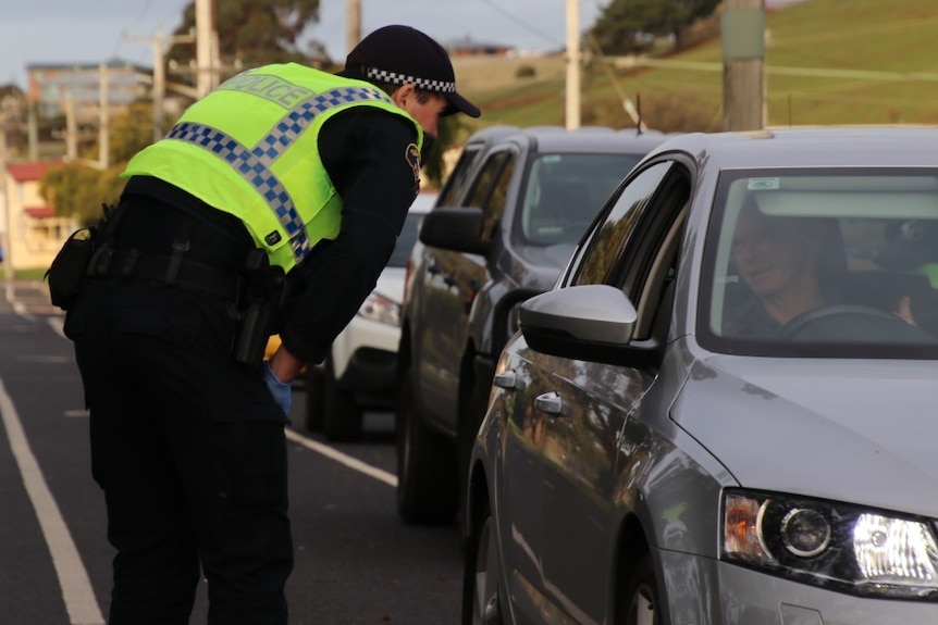 A police officer in Tasmania talks to a driver about their travel