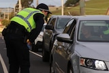 A police officer in Tasmania talks to a driver about their travel