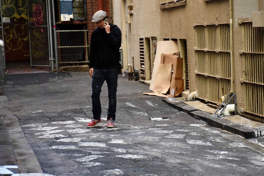 Vincent Fantauzzo on a mobile phone in the laneway.