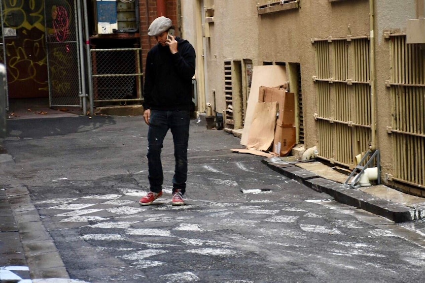 Vincent Fantauzzo on a mobile phone in the laneway.