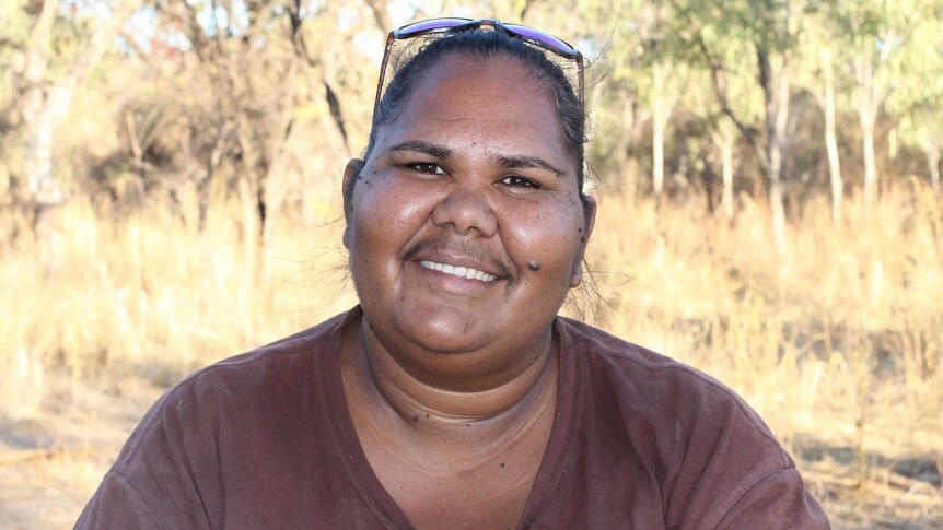 portrait shot of Chantelle Murray smiling at camera, in front of bushland