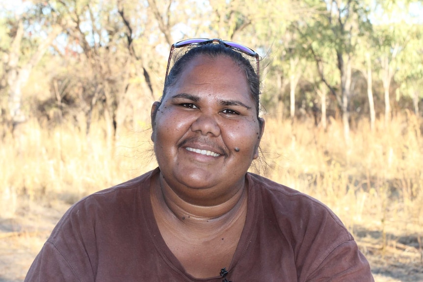 portrait shot of Chantelle Murray smiling at camera, in front of bushland