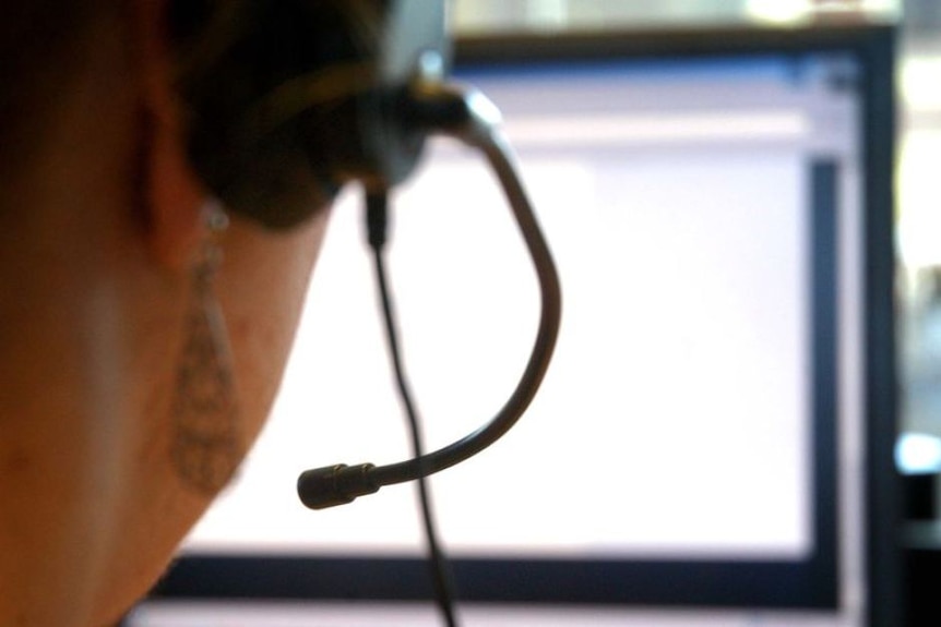 Back of person's head wearing a computer headset and using computer.