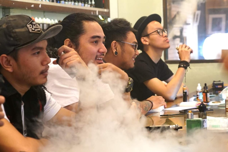 Young men vape in an inner-city vape bar in Jakarta, Indonesia