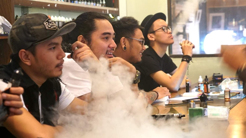 Young men vape in an inner-city vape bar in Jakarta, Indonesia