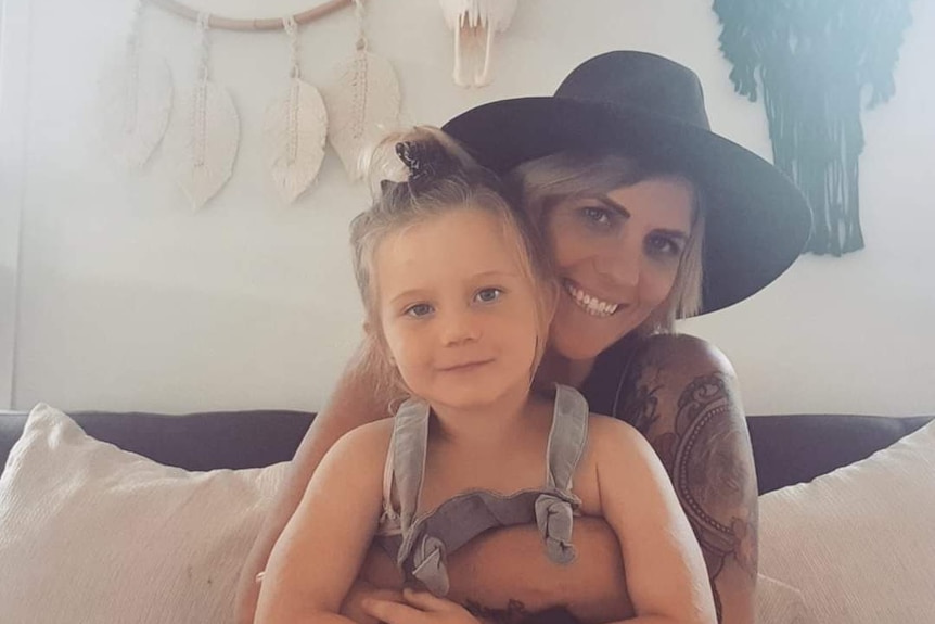 Nikki Hart holds her daughter on her lap