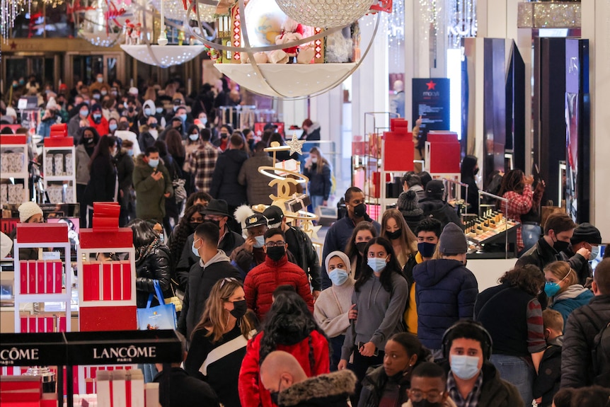 People in face masks shop in Macy's Herald Square