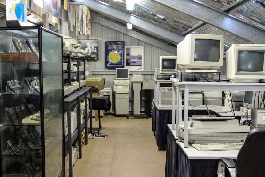 A room with many computers, printers and calculators on display.