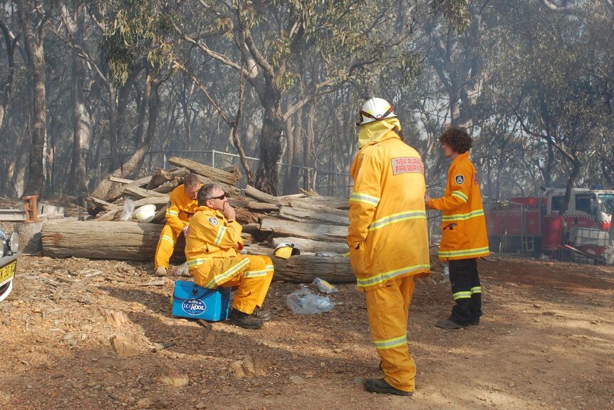A group of fire fighters take a break for water and food.