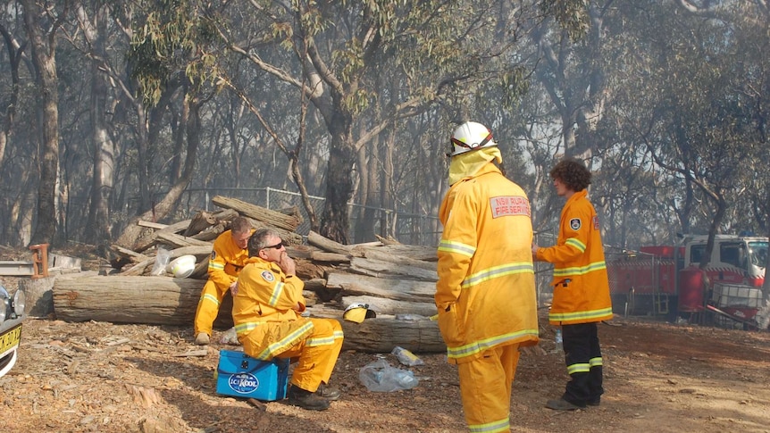 A group of fire fighters take a break for water and food.