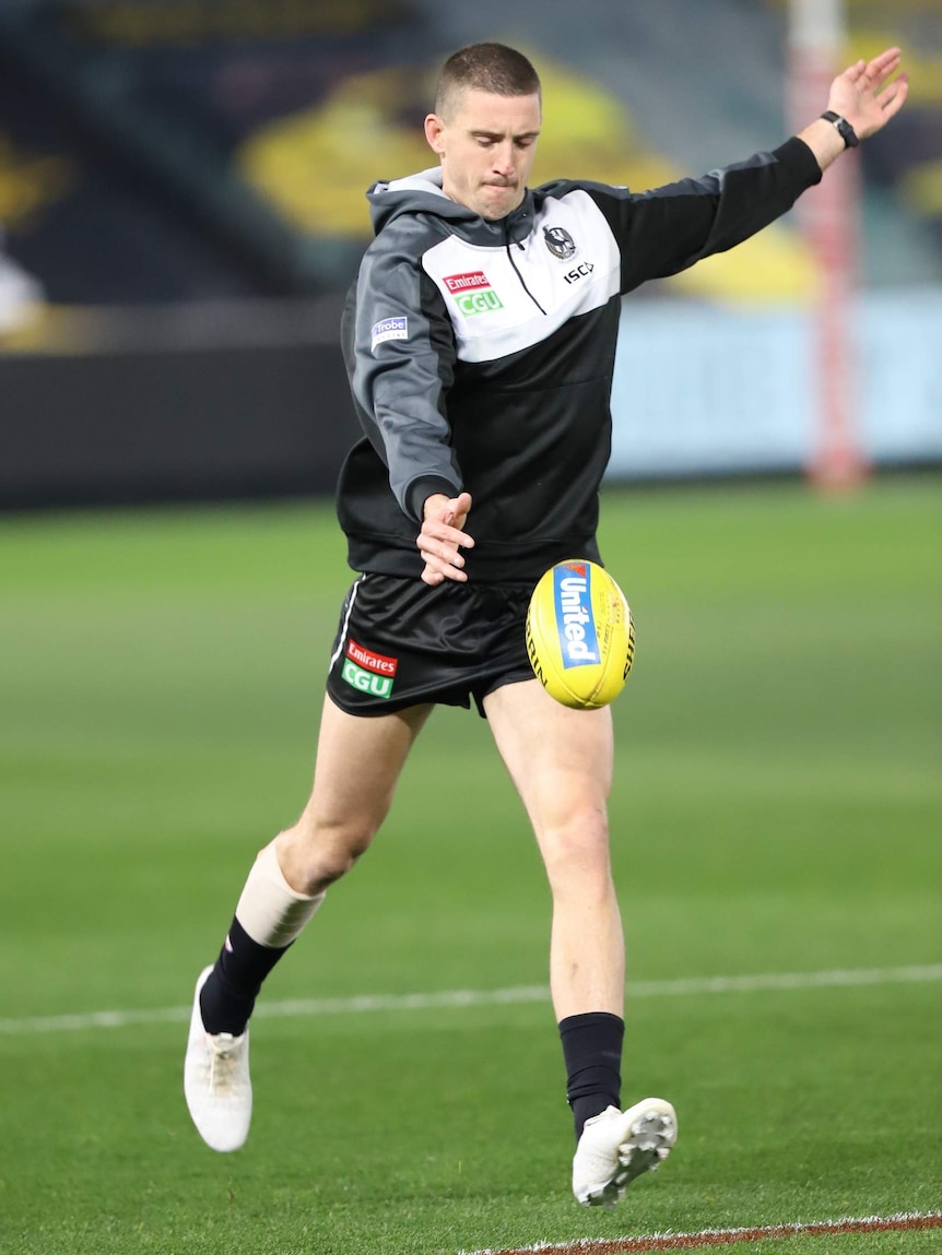 Darcy Cameron warms up ahead of his first game for the Pies.