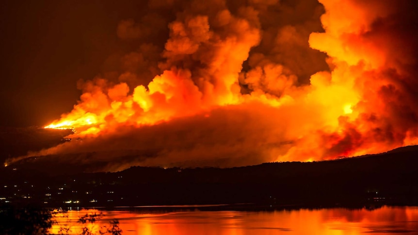 Fires burn across a mountainside at night.