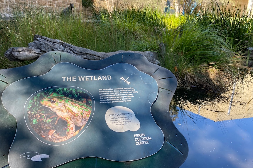 a sign with a picture of a frog in the wetland