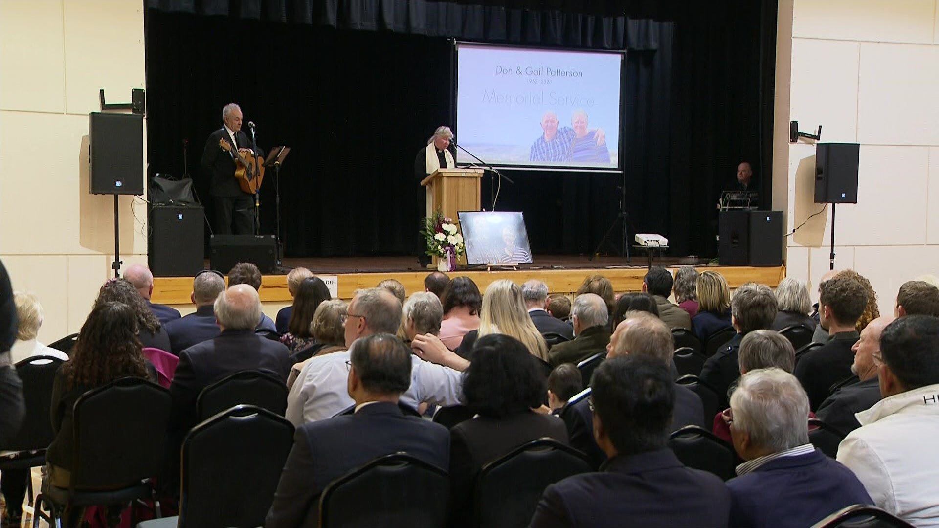 A memorial service with a stage, podium and projector