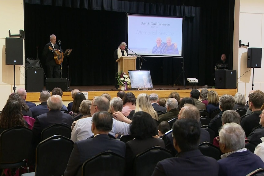 A memorial service with a stage, podium and projector