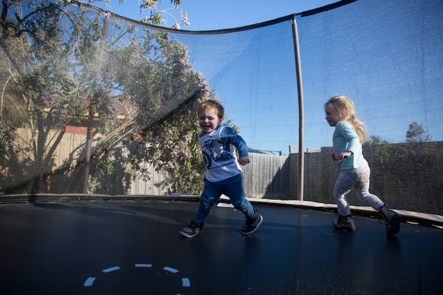 Roman and Nara chase each other on the trampoline.