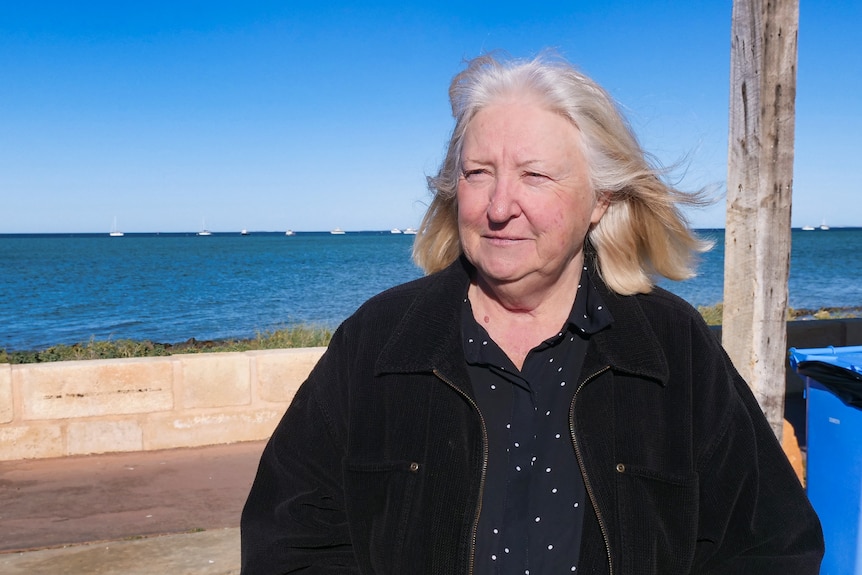 Une femme debout sur un estran de plage.