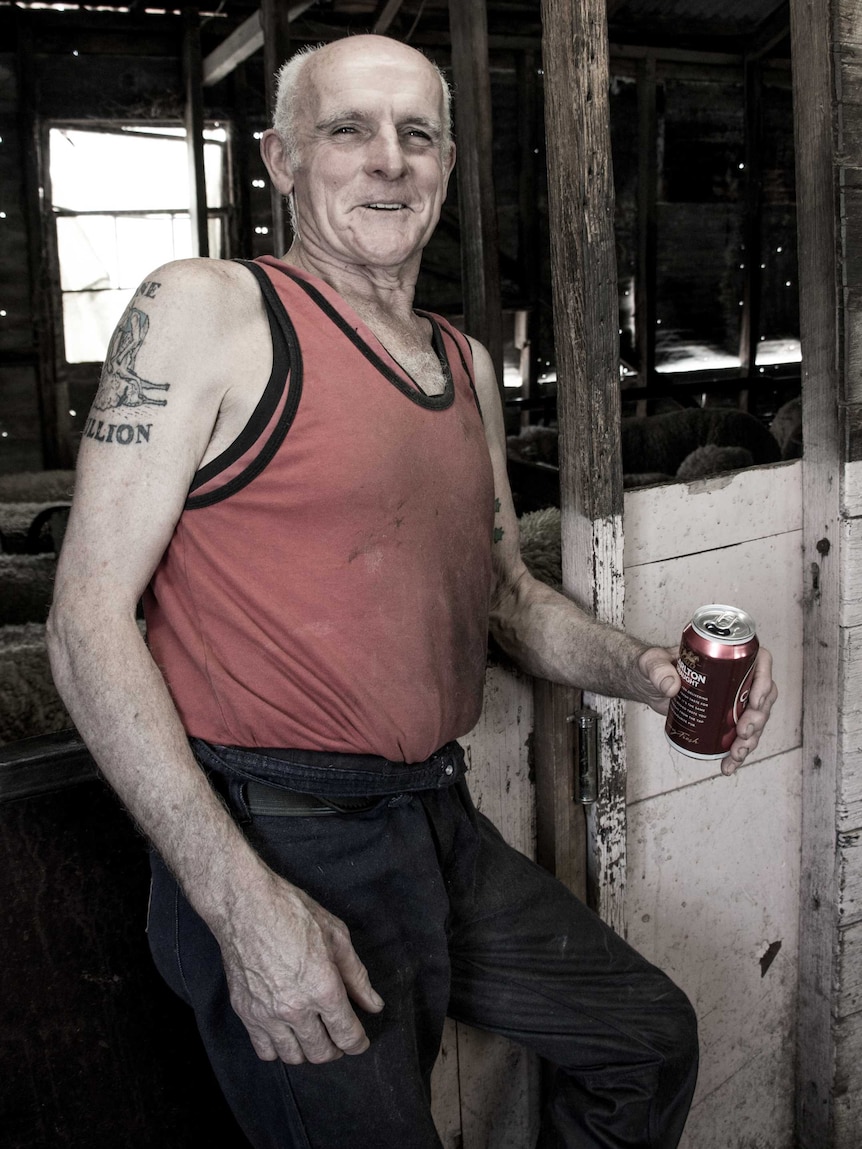 Trevor Kearns stands in the shearing shed with a tinnie in hand.