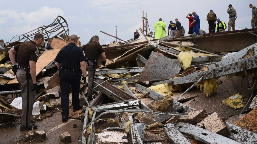Rescue workers search for survivors among the wreckage.