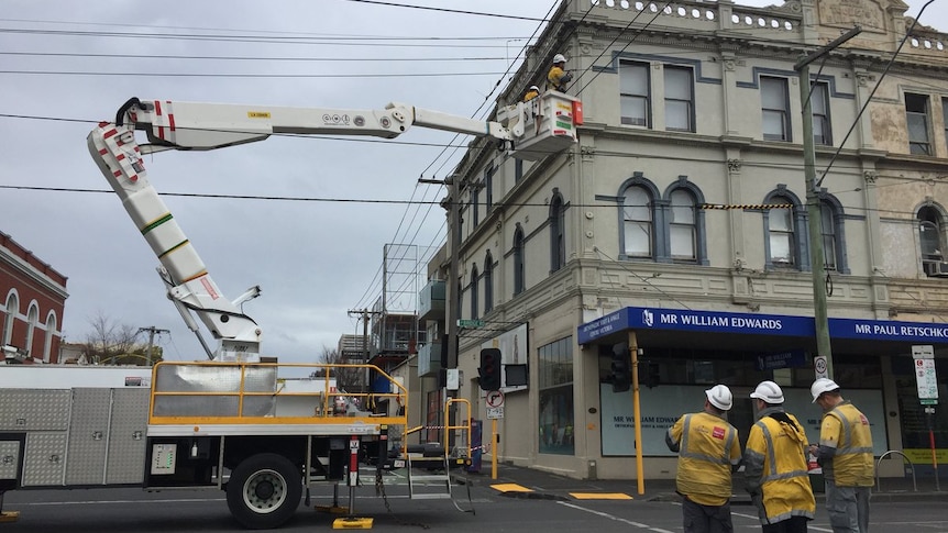 A power crew in a cherry picker disconnecting electricity to a building in Lennox St Richmond.