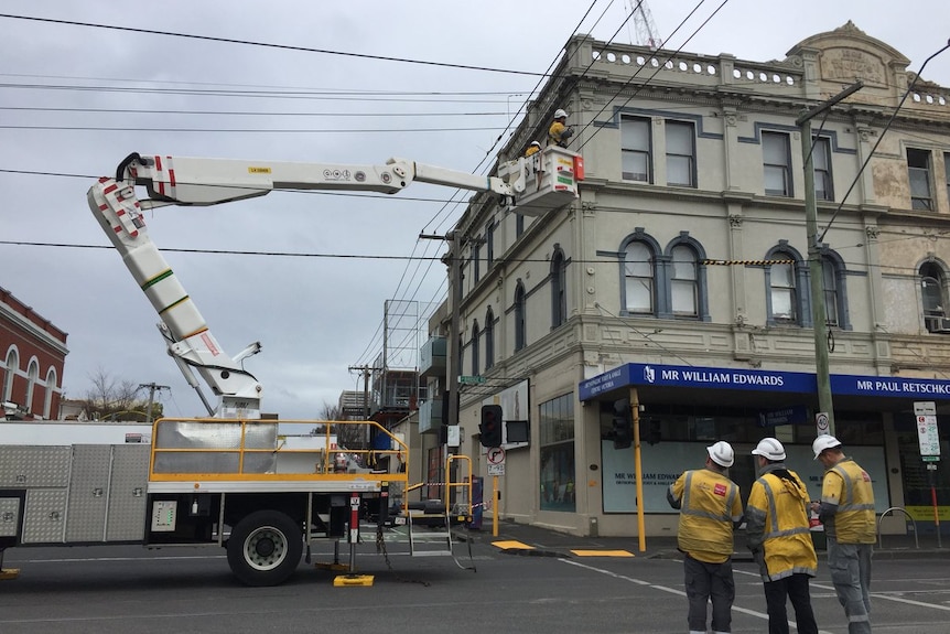 A power crew in a cherry picker disconnecting electricity to a building in Lennox St Richmond.