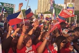 Supporters of Rodrigo Duterte wave flags and cheer.