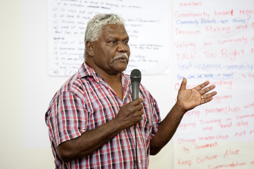 Ian Gumbula speaking into a microphone