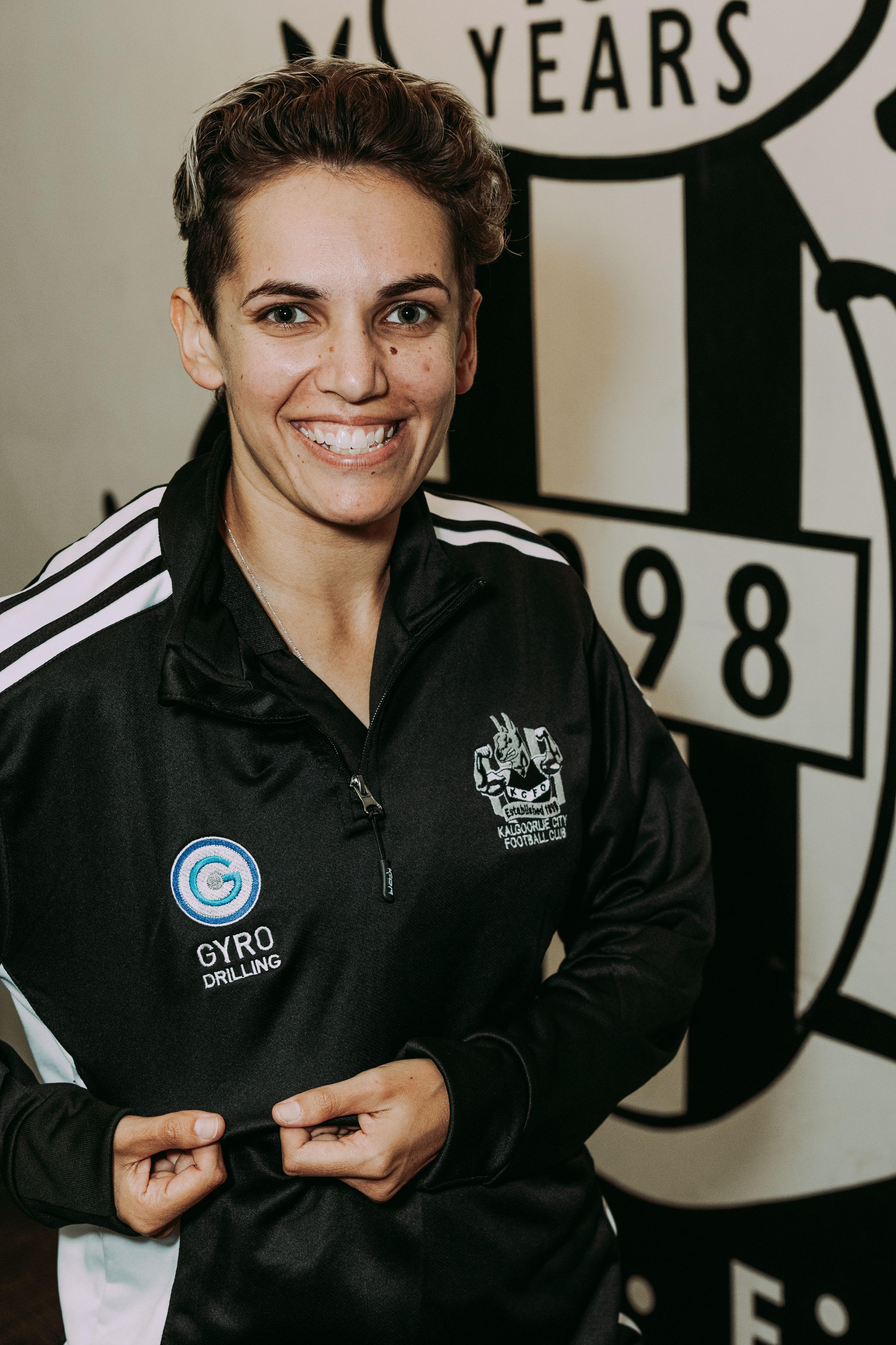 A woman smiling at a football club.  