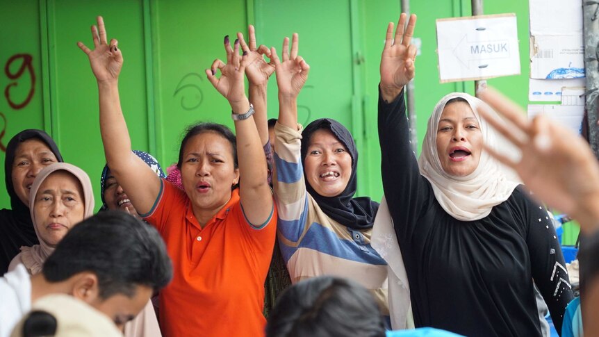 Three women voters celebrating Anies Baswedan's win.