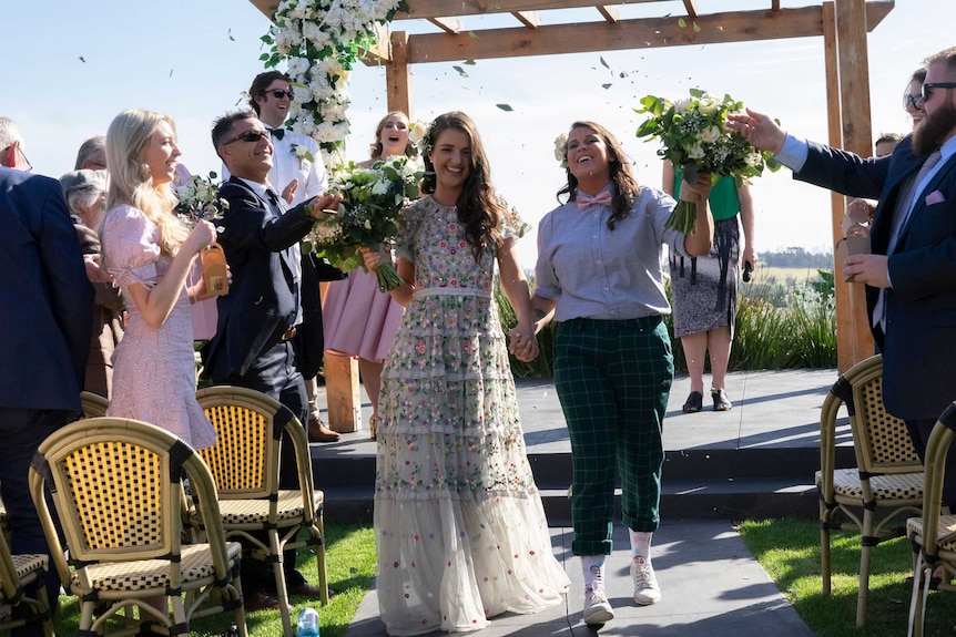 Anna and Bec on their wedding day walking back down the aisle to depict options for your surname after the wedding.