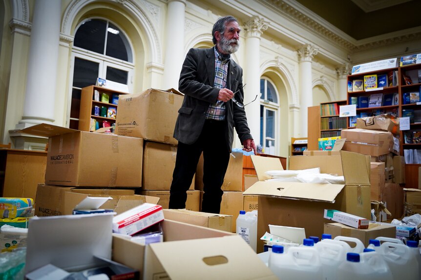 Ivan Svarnyk stands among boxes of medical supplies