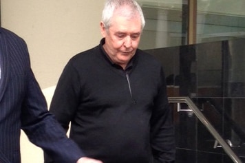 Ian Stuart McAlpine walks down steps outside a court building in Perth wearing a black jumper and pants.