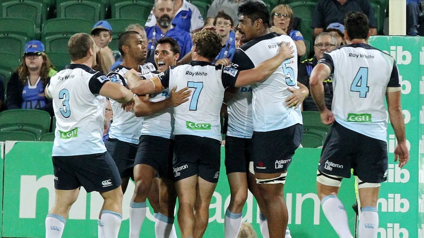 Waratahs players celebrate a try against the Force