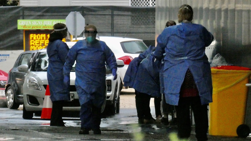 People wearing PPE in wintry conditions with cars