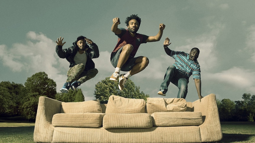 A promo shot for Donald Glover's FX series Atlanta, showing the cast leaping onto a beat-up couch