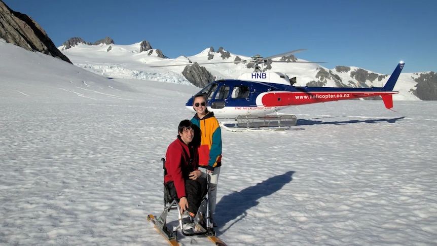 Braeden Jones and sister Amelia on a snowy mountain top in New Zealand. Braedon has wheelchair skis. 
