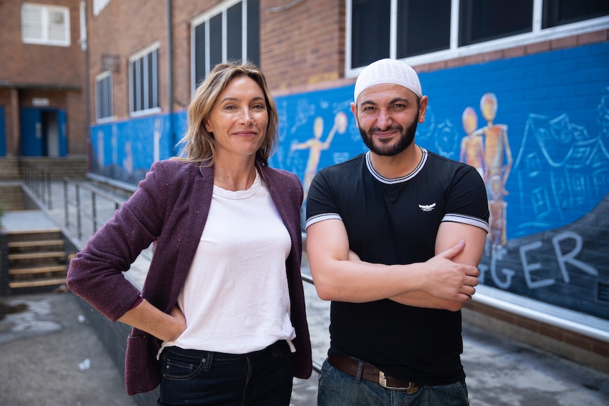 A woman and man stand next to each other in a highschool courtyard. 