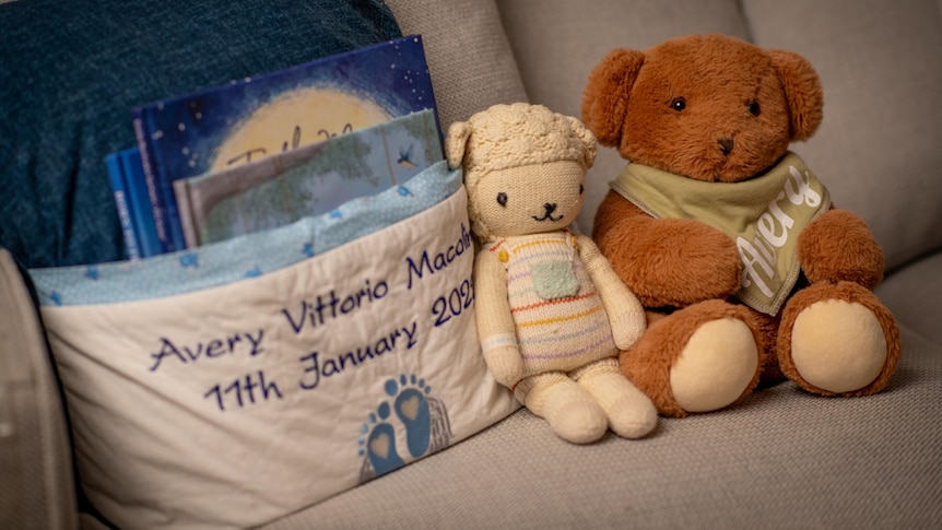 A toy teddy bear and lamb on a couch. 