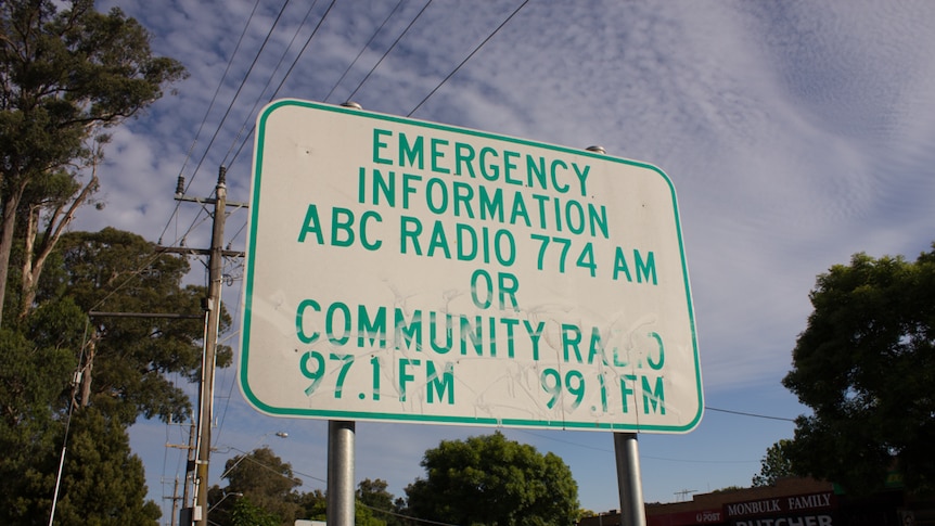 Sign reads: Emergency Information, ABC Radio 774 AM or Community Radio 97.1 FM, 99.1 FM