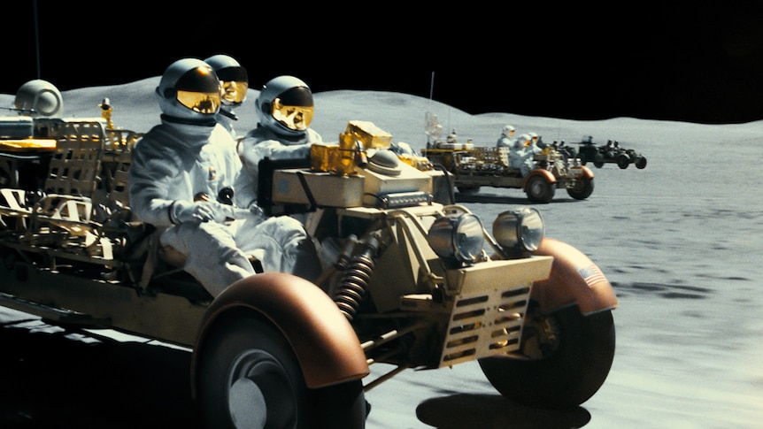 Moonscape with people in space suits on buggies.