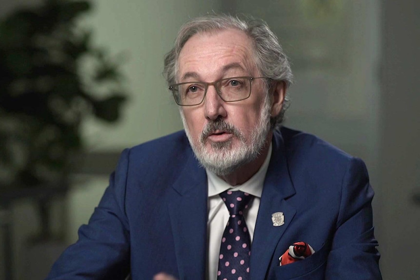 A man wearing a blue suit and tie.